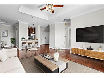 Bright and airy living room with wood floors, a coffered ceiling, and a modern entertainment center at 325 E Paces Ferry Ne Rd # 703, Atlanta, GA 30305