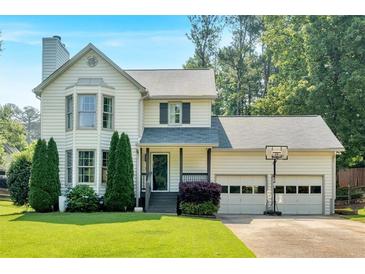 Charming two-story home with a well-manicured lawn, mature trees, and an attached two-car garage with a basketball hoop at 285 Sw Martin Sw Way, Marietta, GA 30064