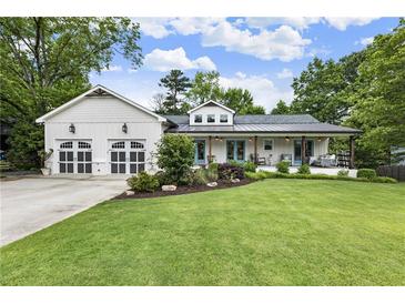 Charming home with a well-manicured lawn and a two-car garage, nestled under a beautiful blue sky at 221 Brooke Dr., Alpharetta, GA 30009