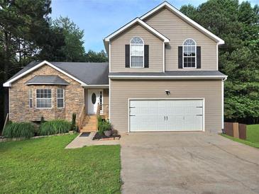 Inviting two-story home with a two-car garage, stone accents, and well-maintained lawn at 4284 Caroline Ct, Douglasville, GA 30135