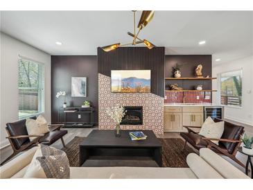 Inviting living room with a fireplace, bar area, stylish light fixture, and comfortable seating at 3087 Alston Dr, Decatur, GA 30032