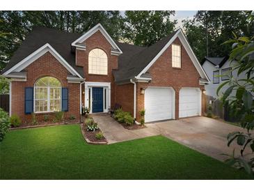 Charming two-story brick home with a well-manicured lawn and a two-car garage at 565 Saint James Ct, Lawrenceville, GA 30044