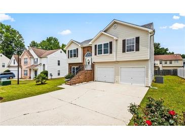 Two-story home with a well-maintained lawn, driveway, and a two-car garage in a suburban neighborhood at 1543 Blossom Dr, Atlanta, GA 30349