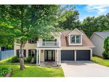 Charming two-story home boasts a welcoming front porch, two-car garage, and lush landscaping, perfect for curb appeal at 1086 Erie Cir, Stone Mountain, GA 30087