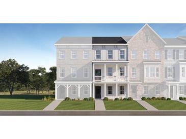 Charming townhome exterior with manicured lawn, walkway, and porch with white columns under a blue sky at 811 Atkins Ln, Woodstock, GA 30188