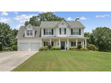Charming two-story home boasts a manicured lawn and inviting columned front porch at 105 Pine Valley Ct, Hiram, GA 30141