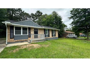 Charming single-story home featuring a brick facade, gray siding, and a well-maintained front lawn at 38 Royce Dr, Jonesboro, GA 30238