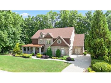 Charming brick two-story home with a covered front porch and well-manicured landscaping at 103 Millstone Way, Canton, GA 30115