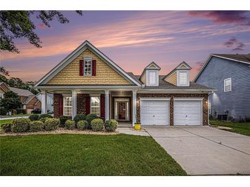 Charming two-story home features a two-car garage, manicured lawn, and beautiful landscaping at 4200 Vinca Way, Union City, GA 30291