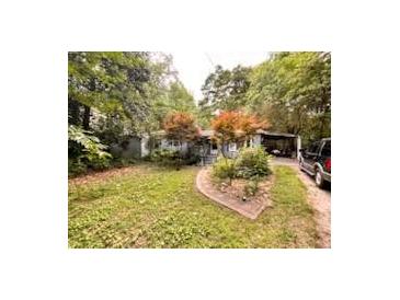 Cozy single-story home featuring a covered carport and a partially wooded front yard at 3617 Bob White Ln, Loganville, GA 30052