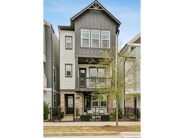Charming three-story home features a black metal fence, balcony, and a combination of siding and brick at 522 Hargrove Ln, Decatur, GA 30030