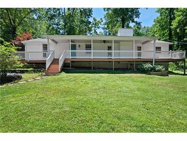Charming single-story home featuring a full front porch and well-maintained lawn surrounded by mature trees at 5971 Dogwood Se Dr, Acworth, GA 30102