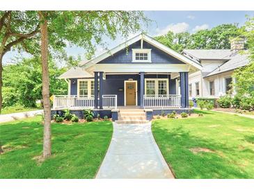 Charming home showcasing a well-manicured lawn, quaint porch, and blue exterior at 1253 Lucile Sw Ave, Atlanta, GA 30310