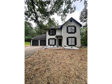 Charming two-story home with an attached two-car garage and a beautifully landscaped front yard at 2720 Thornbury Way, Atlanta, GA 30349