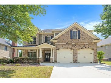 Charming two-story brick home with a well-manicured lawn and a two-car garage at 585 Lawton Bridge Sw Rd, Smyrna, GA 30082