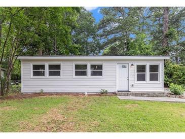 Charming single-story home with a white exterior, complemented by well-maintained landscaping and mature trees at 340 Bell Se St, Marietta, GA 30060
