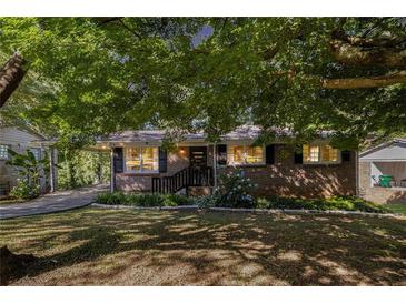 Charming brick home with a landscaped front yard and covered parking at 863 Needle Rock Dr, Stonecrest, GA 30083
