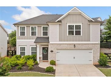 Charming two-story home featuring a brick and siding facade, complemented by a well-maintained front yard and a two car garage at 306 Coppergate Ct, Holly Springs, GA 30115