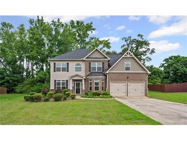 Charming two-story home featuring a well-manicured lawn and attached two-car garage at 397 Victory Ln Ln, Locust Grove, GA 30248