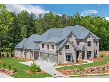 Stately brick home featuring a manicured lawn, a three-car garage, and a charming walkway at 4927 Slaton Dr, Acworth, GA 30101