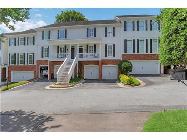 Charming townhome with brick accents, multiple garage spaces, and a welcoming front porch at 620 Neel Reid Dr, Roswell, GA 30075