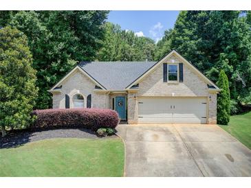 Charming one story brick home with a manicured lawn, attached garage and inviting curb appeal at 130 Stewart Hollow Ln, Covington, GA 30016
