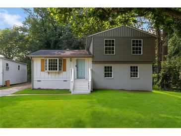 Charming home featuring a well-manicured lawn, updated two-tone paint, and a inviting front entrance at 6192 Holiday Blvd, Forest Park, GA 30297