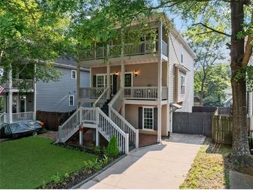 Charming two-story home featuring double porches, a landscaped yard, and a private driveway at 944 Herndon Nw St, Atlanta, GA 30318