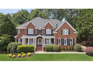 Charming two-story brick home with a well-manicured lawn and mature landscaping at 2145 Sugarstone Ct, Lawrenceville, GA 30043