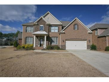 Traditional brick home with a two-car garage and a well-manicured lawn under a partly cloudy sky at 7790 Stratford Ln, Atlanta, GA 30350