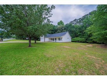 Charming single story home with a well-manicured lawn and mature trees at 40 Heather Woods Ct, Covington, GA 30016