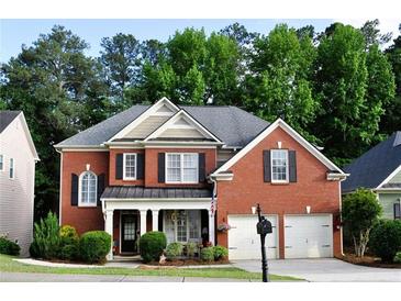 Charming brick home with well-manicured landscaping, covered porch, and two-car garage at 1951 Barrett Knoll Nw Cir, Kennesaw, GA 30152