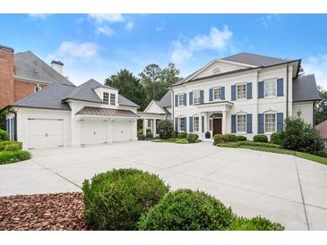 Stunning two-story home with blue shutters, three-car garage, and a spacious driveway at 6440 Westchester Pl, Cumming, GA 30040