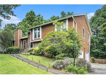 Charming split level home with a stone accent wall and lush landscaping at 8605 Stone Creek Ct, Douglasville, GA 30135