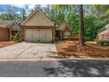 Charming brick home featuring a well-manicured lawn and a two-car garage at 3221 Abbott Dr # 5, Powder Springs, GA 30127