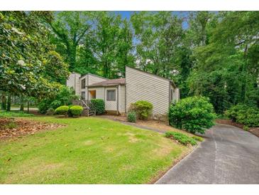 Charming home with a lush lawn and mature trees surrounding the property at 766 Lost Creek Cir, Stone Mountain, GA 30088