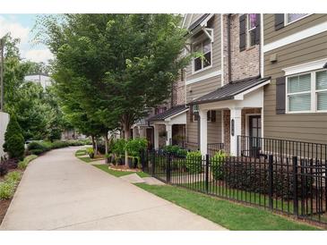 Charming townhome with manicured lawn and iron fence, providing a secure and inviting curb appeal at 318 Lantana Ln, Woodstock, GA 30188