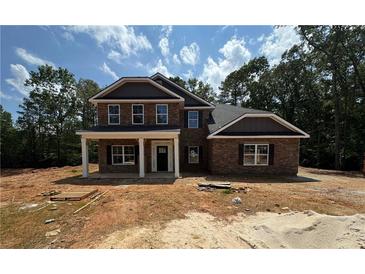 A new two-story brick home with a covered porch and a yard ready for landscaping at 5361 Tuscany Dr, Douglasville, GA 30135