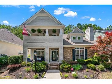 Charming two-story home with stone accents, a cozy porch, and a landscaped front yard at 859 Scales Rd, Suwanee, GA 30024