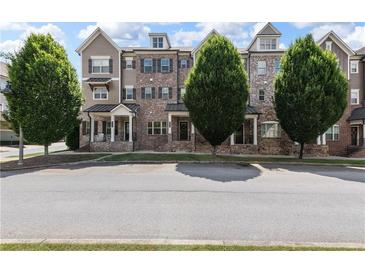 Attractive multi-story townhomes with brick and siding and professionally landscaped front yards, exuding curb appeal at 209 Snapdragon St, Woodstock, GA 30188