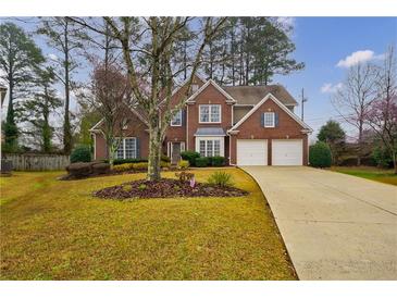 Charming two-story red brick home with well-manicured lawn and a two-car garage at 2720 Stillwater Lake Ln, Marietta, GA 30066
