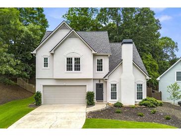 Charming two-story home with landscaped yard, attached garage, and neutral color palette at 3040 Ivey Oaks Ln, Roswell, GA 30076