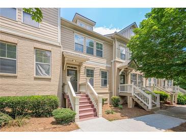 Beautiful townhome featuring a brick and siding exterior, landscaped front yard, and inviting front entrance at 4404 Village Field Pl, Suwanee, GA 30024