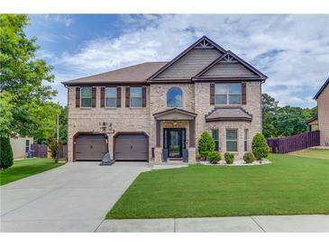 Charming two-story brick home with a two-car garage and well-manicured lawn at 206 Traditions Dr, Loganville, GA 30052