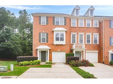 Charming brick townhome with manicured landscaping, attached garage, and inviting entryway at 5589 Trace Views Dr, Norcross, GA 30071