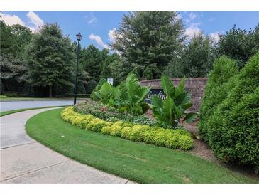 A charming street view of a home community with brick signage and lush landscaping at 1547 Paxton Sw Dr, Lilburn, GA 30047