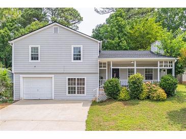 Charming home featuring a welcoming front porch and well-manicured lawn at 2320 Boone Pl, Snellville, GA 30078