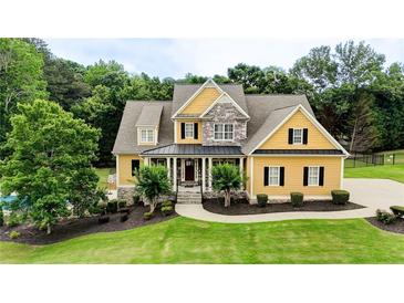 Charming two-story home featuring a well-manicured lawn, complemented by lush landscaping, a backyard pool and a stone facade at 116 Archstone Sq, Mcdonough, GA 30253
