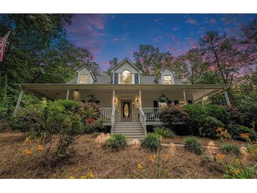 Charming home with a welcoming front porch, lush landscaping, and a serene setting at 83 Shipp Cir, Hiram, GA 30141