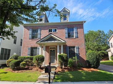 Charming two-story brick home with symmetrical windows, dormers, and manicured front yard landscaping at 1666 Baxley Pine Trce, Suwanee, GA 30024